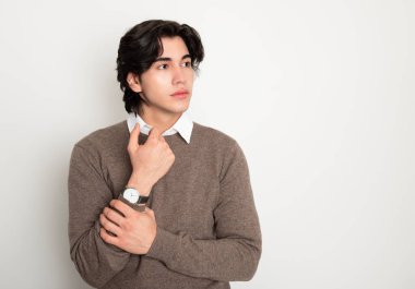 Metal kol saati takan, şık, rahat giyimli yakışıklı bir genç.