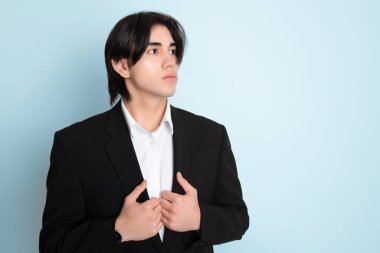 Metal kol saati takan, şık, rahat giyimli yakışıklı bir genç.