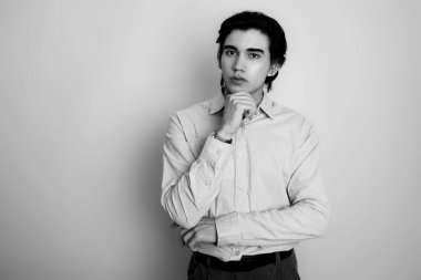 Metal kol saati takan, şık, rahat giyimli yakışıklı bir genç.