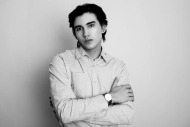 Metal kol saati takan, şık, rahat giyimli yakışıklı bir genç.