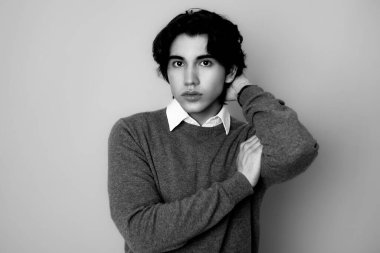 Metal kol saati takan, şık, rahat giyimli yakışıklı bir genç.