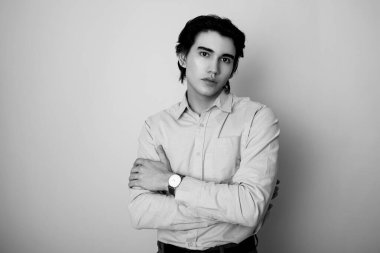 Metal kol saati takan, şık, rahat giyimli yakışıklı bir genç.