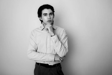 Metal kol saati takan, şık, rahat giyimli yakışıklı bir genç.