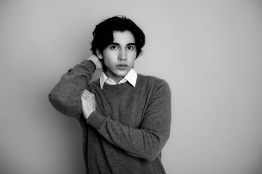 Metal kol saati takan, şık, rahat giyimli yakışıklı bir genç.