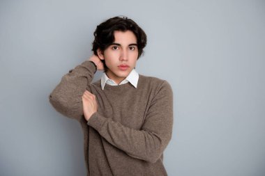 Metal kol saati takan, şık, rahat giyimli yakışıklı bir genç.