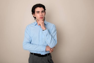 Metal kol saati takan, şık, rahat giyimli yakışıklı bir genç.