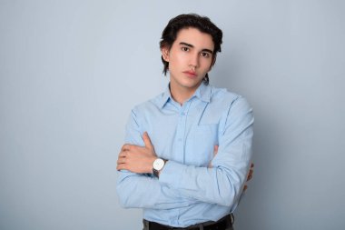 Metal kol saati takan, şık, rahat giyimli yakışıklı bir genç.