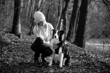 Kadın ve onun sevimli köpekleri ormanda yürüyüş yapıyor, oynuyor, egzersiz yapıyor ve eğleniyorlar.
