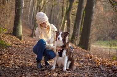 Kadın ve onun sevimli köpekleri ormanda yürüyüş yapıyor, oynuyor, egzersiz yapıyor ve eğleniyorlar.
