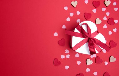 Sevgililer günü ya da yıldönümü kutlamaları için pembe hediye ve kırmızı kurdeleli güller ve kopyalama alanı ile güzel ve şenlikli bir arka plan.