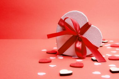 Sevgililer günü ya da yıldönümü kutlamaları için pembe hediye ve kırmızı kurdeleli güller ve kopyalama alanı ile güzel ve şenlikli bir arka plan.