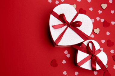 Sevgililer günü ya da yıldönümü kutlamaları için pembe hediye ve kırmızı kurdeleli güller ve kopyalama alanı ile güzel ve şenlikli bir arka plan.