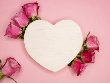 Sevgililer günü ya da yıldönümü kutlamaları için pembe hediye ve kırmızı kurdeleli güller ve kopyalama alanı ile güzel ve şenlikli bir arka plan.