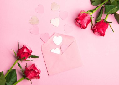 Sevgililer günü, doğum günü ya da yıldönümü kutlamaları için güzel ve şenlikli bir geçmiş. Kırmızı güller ve yazı için beyaz kalp şeklinde bir kart.