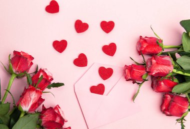 Sevgililer günü, doğum günü ya da yıldönümü kutlamaları için güzel ve şenlikli bir geçmiş. Kırmızı güller ve yazı için beyaz kalp şeklinde bir kart.