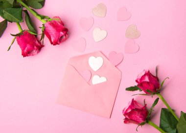 Sevgililer günü, doğum günü ya da yıldönümü kutlamaları için güzel ve şenlikli bir geçmiş. Kırmızı güller ve yazı için beyaz kalp şeklinde bir kart.