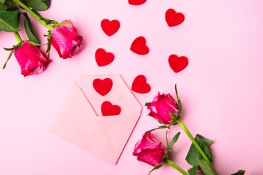 Sevgililer günü, doğum günü ya da yıldönümü kutlamaları için güzel ve şenlikli bir geçmiş. Kırmızı güller ve yazı için beyaz kalp şeklinde bir kart.