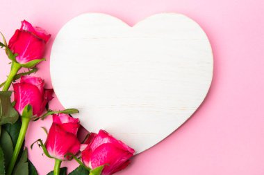 Sevgililer günü, doğum günü ya da yıldönümü kutlamaları için güzel ve şenlikli bir geçmiş. Kırmızı güller ve yazı için beyaz kalp şeklinde bir kart.