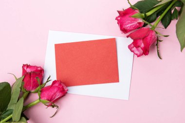 Sevgililer günü, doğum günü ya da yıldönümü kutlamaları için güzel ve şenlikli bir geçmiş. Kırmızı güller ve yazı için beyaz kalp şeklinde bir kart.