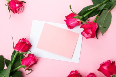 Sevgililer günü, doğum günü ya da yıldönümü kutlamaları için güzel ve şenlikli bir geçmiş. Kırmızı güller ve yazı için beyaz kalp şeklinde bir kart.