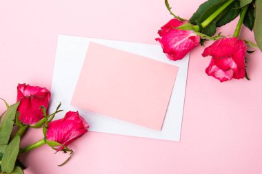 Sevgililer günü, doğum günü ya da yıldönümü kutlamaları için güzel ve şenlikli bir geçmiş. Kırmızı güller ve yazı için beyaz kalp şeklinde bir kart.