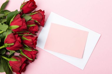 Sevgililer günü, doğum günü ya da yıldönümü kutlamaları için güzel ve şenlikli bir geçmiş. Kırmızı güller ve yazı için beyaz kalp şeklinde bir kart.