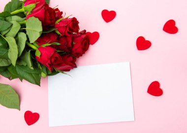 Sevgililer günü, doğum günü ya da yıldönümü kutlamaları için güzel ve şenlikli bir geçmiş. Kırmızı güller ve yazı için beyaz kalp şeklinde bir kart.