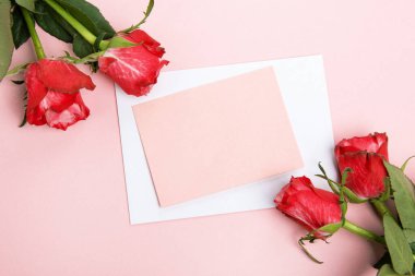 Sevgililer günü, doğum günü ya da yıldönümü kutlamaları için güzel ve şenlikli bir geçmiş. Kırmızı güller ve yazı için beyaz kalp şeklinde bir kart.