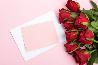 Sevgililer günü, doğum günü ya da yıldönümü kutlamaları için güzel ve şenlikli bir geçmiş. Kırmızı güller ve yazı için beyaz kalp şeklinde bir kart.