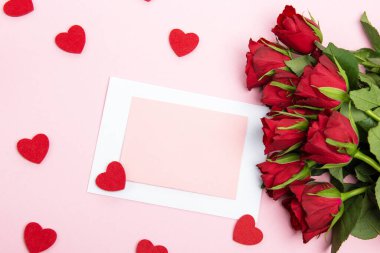 Sevgililer günü, doğum günü ya da yıldönümü kutlamaları için güzel ve şenlikli bir geçmiş. Kırmızı güller ve yazı için beyaz kalp şeklinde bir kart.