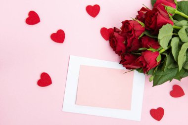 Sevgililer günü, doğum günü ya da yıldönümü kutlamaları için güzel ve şenlikli bir geçmiş. Kırmızı güller ve yazı için beyaz kalp şeklinde bir kart.
