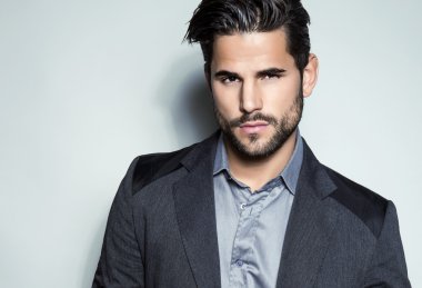 yakışıklı genç gri arka plan üzerinde takım elbiseli