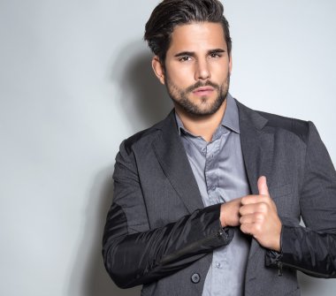 yakışıklı genç gri arka plan üzerinde takım elbiseli