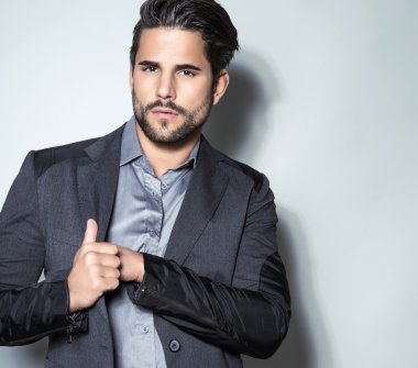 yakışıklı genç gri arka plan üzerinde takım elbiseli