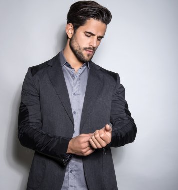 yakışıklı genç gri arka plan üzerinde takım elbiseli