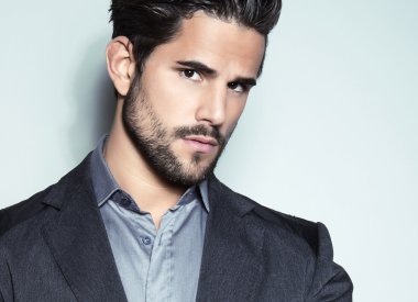 yakışıklı genç gri arka plan üzerinde takım elbiseli