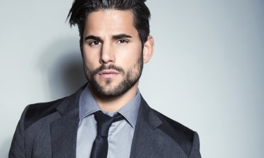 yakışıklı genç gri arka plan üzerinde takım elbiseli