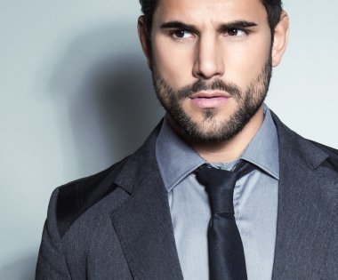 yakışıklı genç gri arka plan üzerinde takım elbiseli