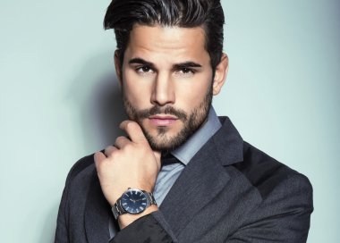 yakışıklı genç gri arka plan üzerinde takım elbiseli