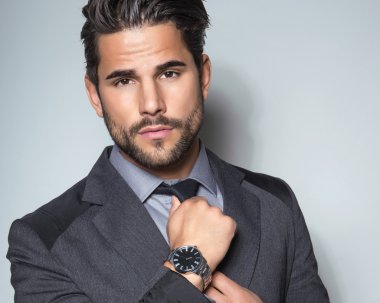 yakışıklı genç gri arka plan üzerinde takım elbiseli