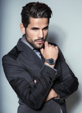 yakışıklı genç gri arka plan üzerinde takım elbiseli