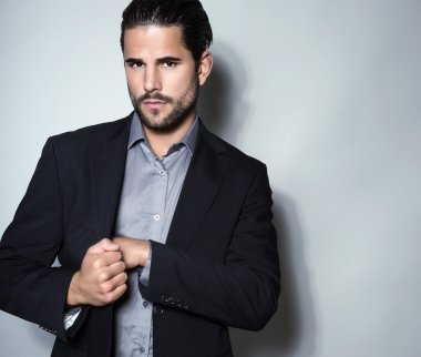 yakışıklı genç gri arka plan üzerinde takım elbiseli