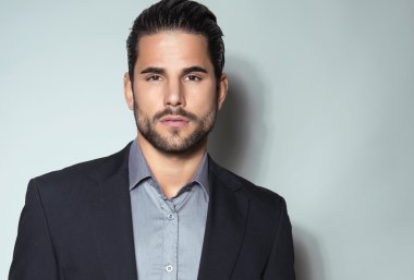 yakışıklı genç gri arka plan üzerinde takım elbiseli