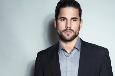 yakışıklı genç gri arka plan üzerinde takım elbiseli