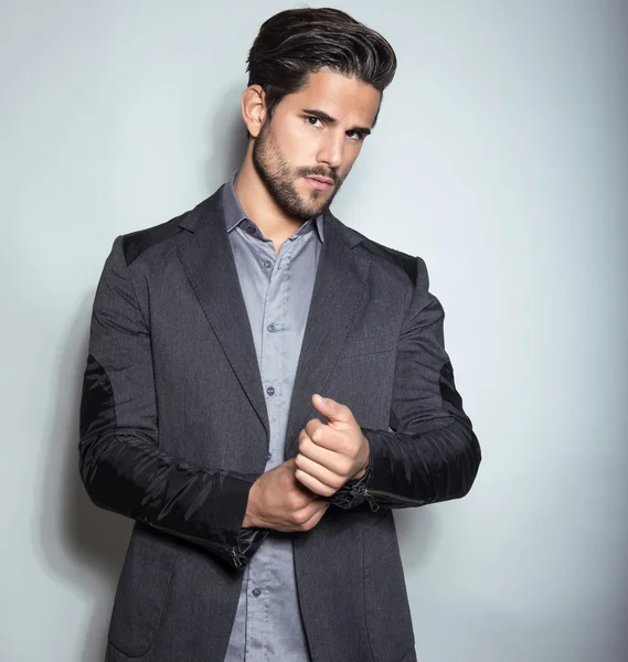 Joven guapo en traje sobre fondo gris —  Fotos de Stock