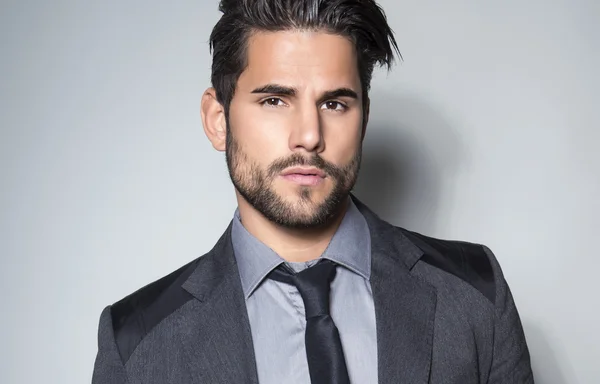 Handsome young man in suit on grey background — Stock Photo, Image