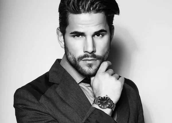 handsome young man in suit on grey background