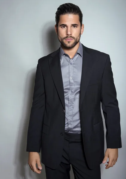 Handsome young man in suit on grey background — Stock Photo, Image