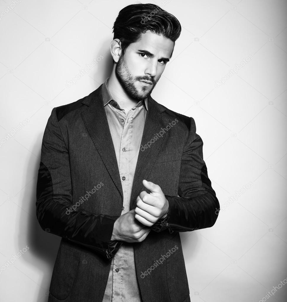 handsome young man in suit on grey background