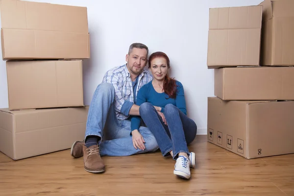 Happy couple  in their new home with cardboard boxes — Stock Photo, Image